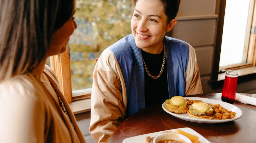 Two people look at each other over breakfast