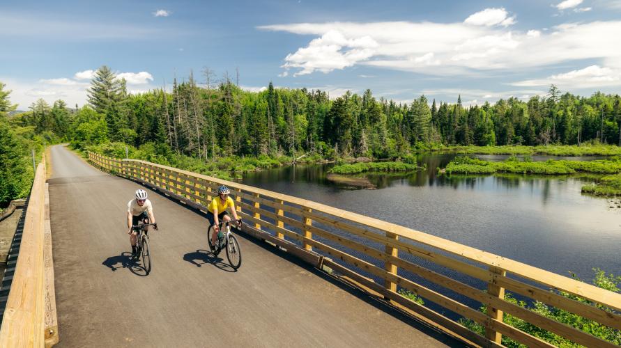 A couple people biking on a gravel rail trail