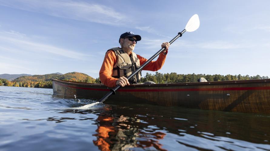 A man paddling a canoe through the water.