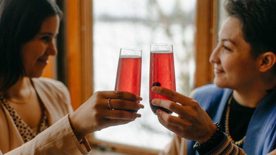 Two women raising their glasses and smiling.