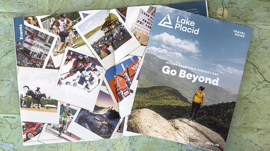 A visitor guide sits on top of an open copy of the guide, showing an array of photos. A map is the background.