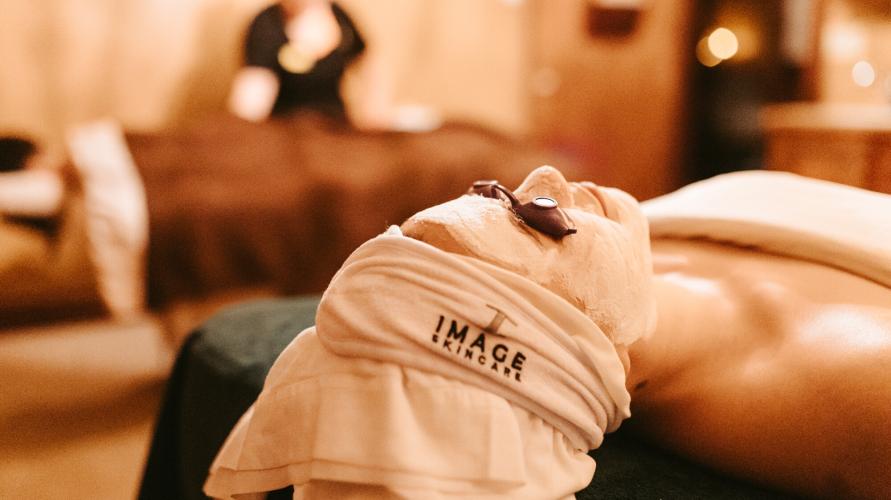 A woman laying down in a spa getting a facial.