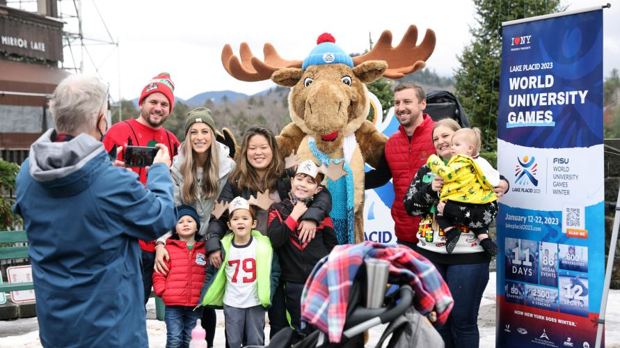 A group of people take a picture with a moose mascot.