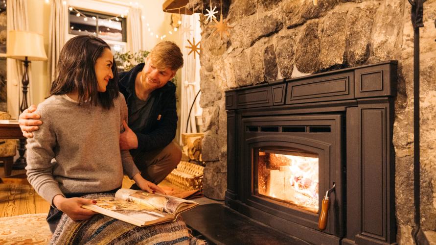 A couple sitting in front of a fireplace.