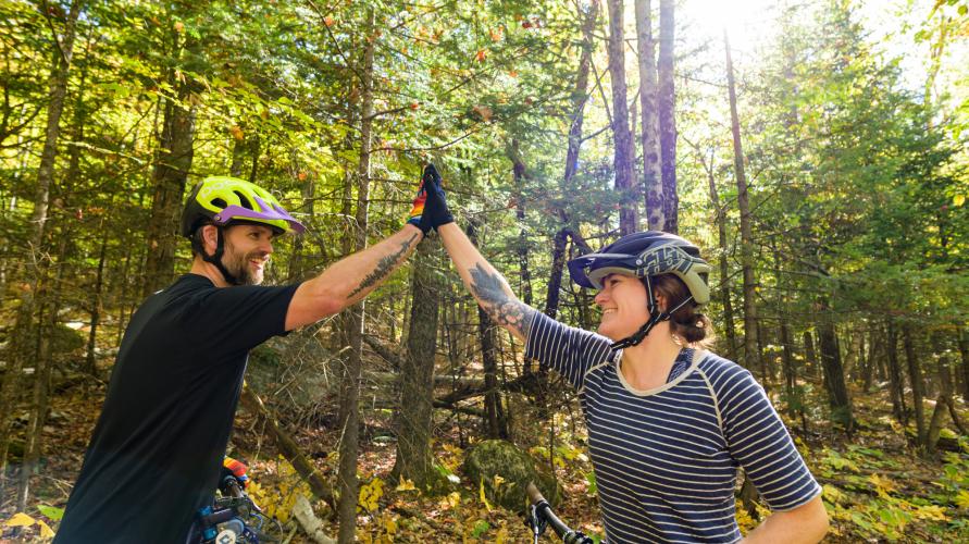 Two mountain bikers high fiving
