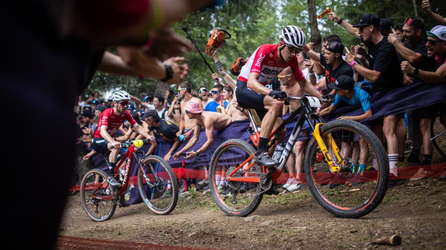 Mountain bikers racing past a cheering crowd