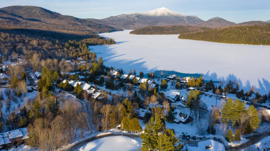 An aerial view of Lake Placid in winter with Whiteface Mountain in the background