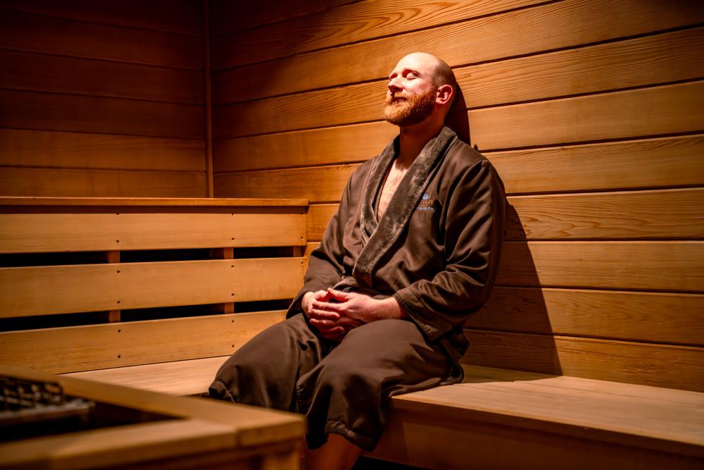 A man sits in a warm sauna