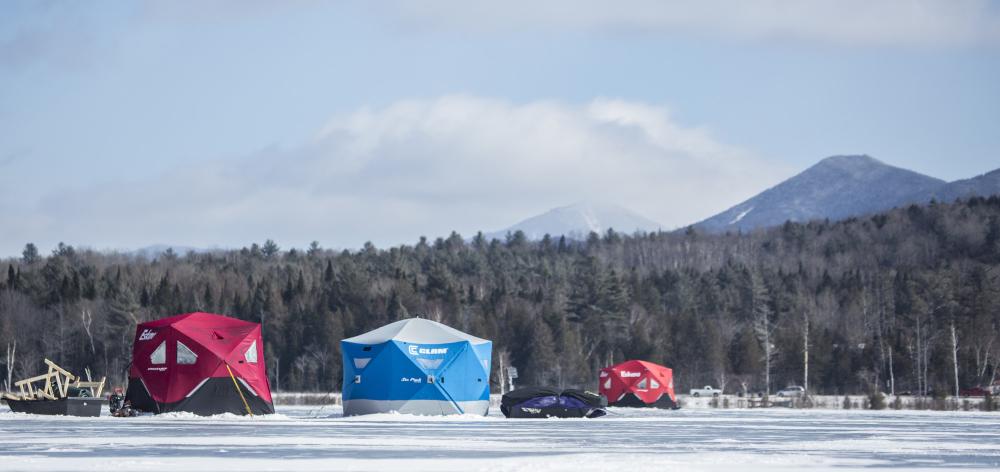 two men lead a sled back to their ice hut.