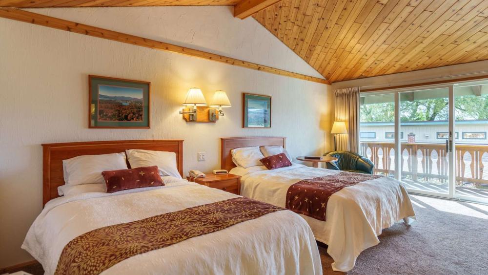 A large, yet cozy Adirondack hotel room with double beds and a high ceiling.