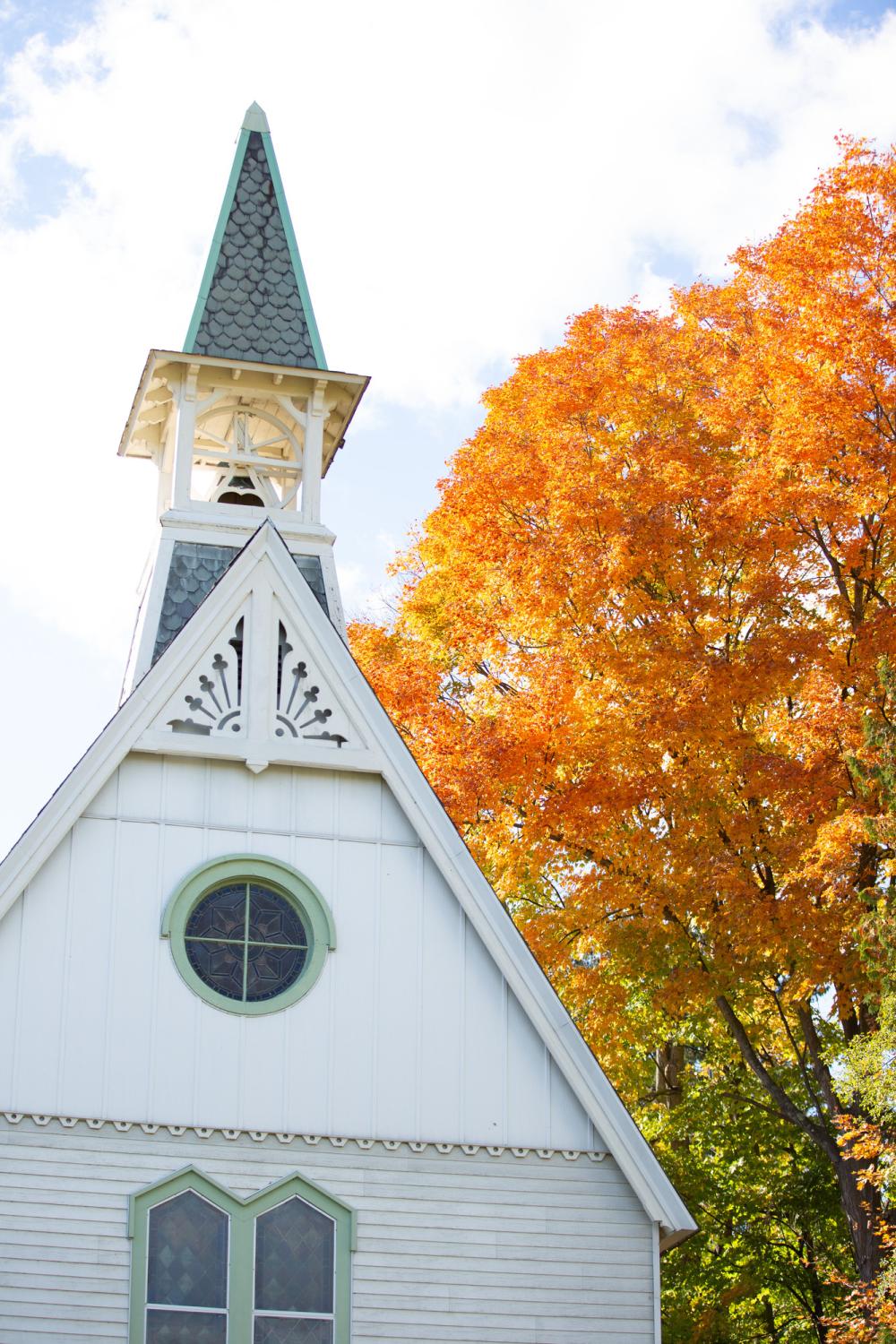 A white church steeple in fall.