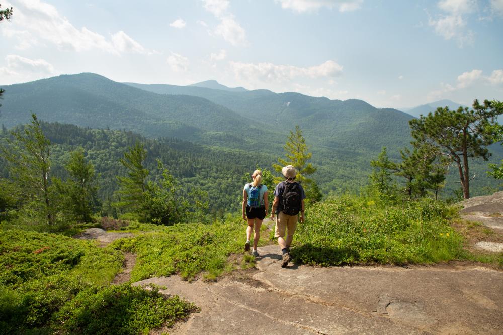 A couple looking out at the summit of Baxter Mountain in the summer.