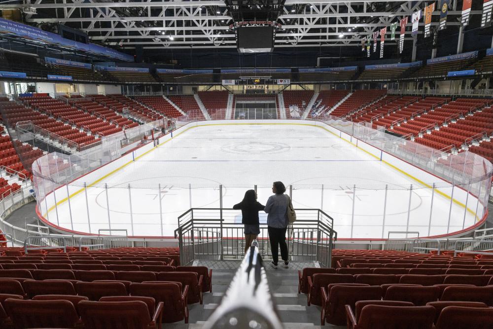 Two people look towards the ice of the 1980 Rink