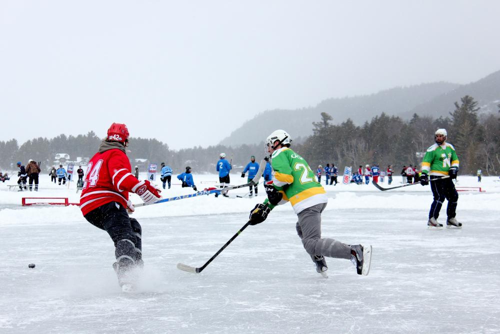 Pond hockey teams skate amid a snowy day.