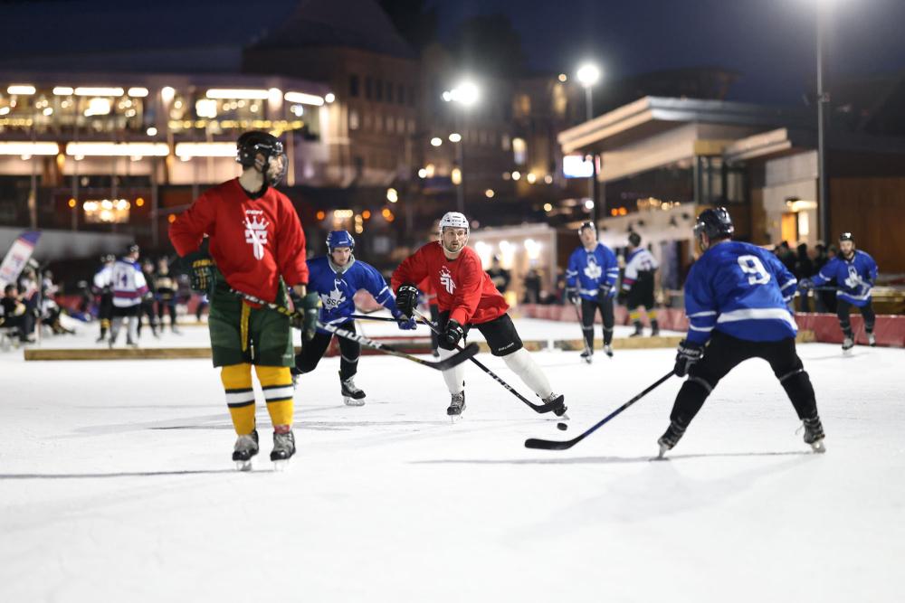 Pickup hockey teams play under the bright outdoor lights of the Lake Placid Olympic Center.