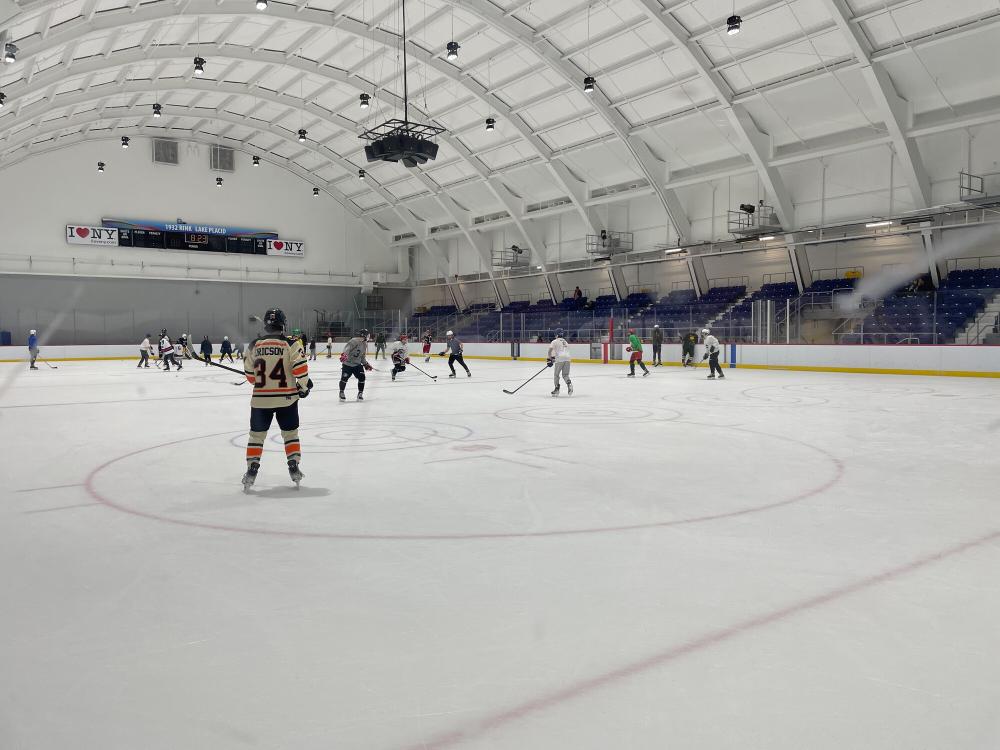 Hockey teams compete at an indoor rink.