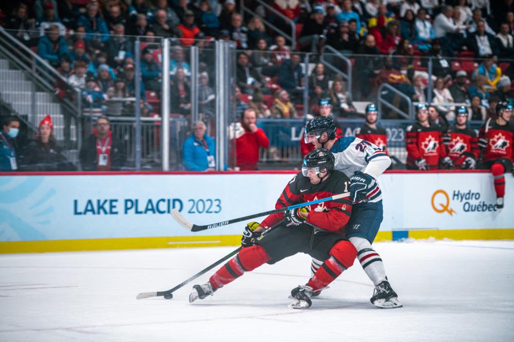 Two international hockey players fight for the puck.