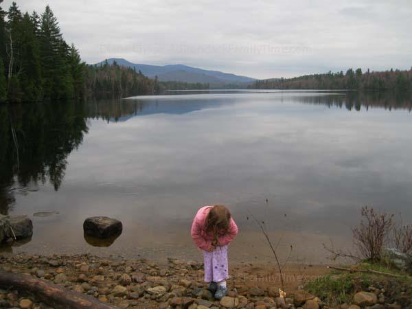 child explores shore of Franklin Falls Pond