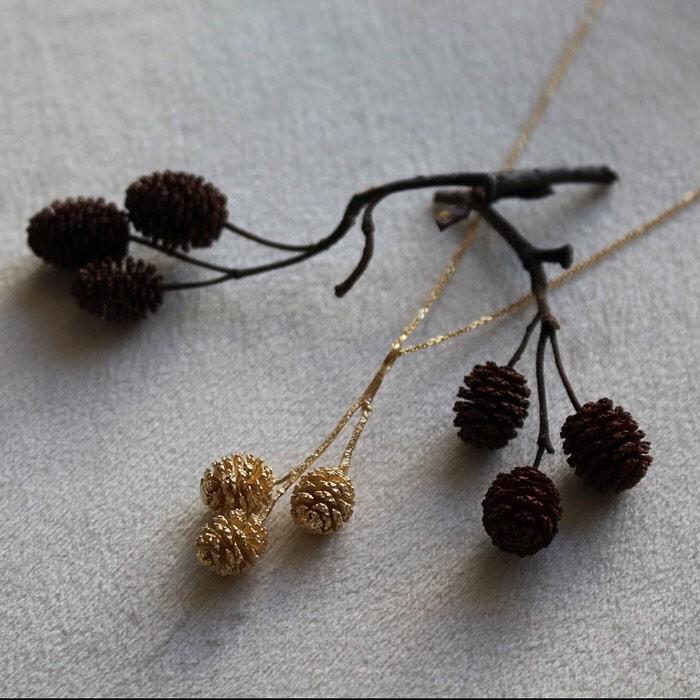 A delicate golden pinecone pendant, a sweet Adirondack souvenir.