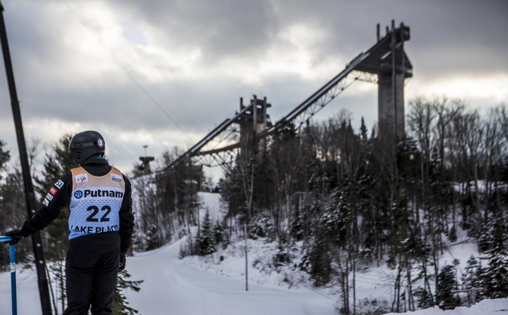 A ski jumper in competition stands before the jumps.