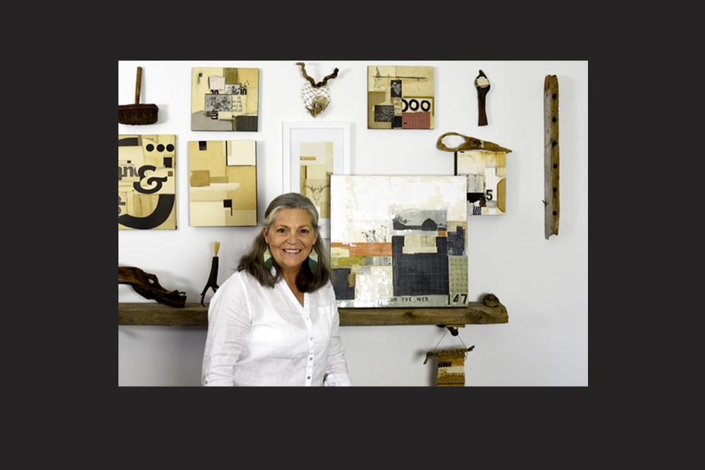 A woman stands with her collage artworks.