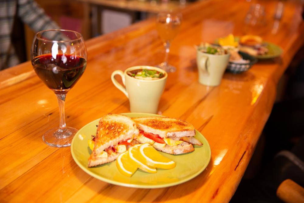 A plate of food and glass of wine on a bar