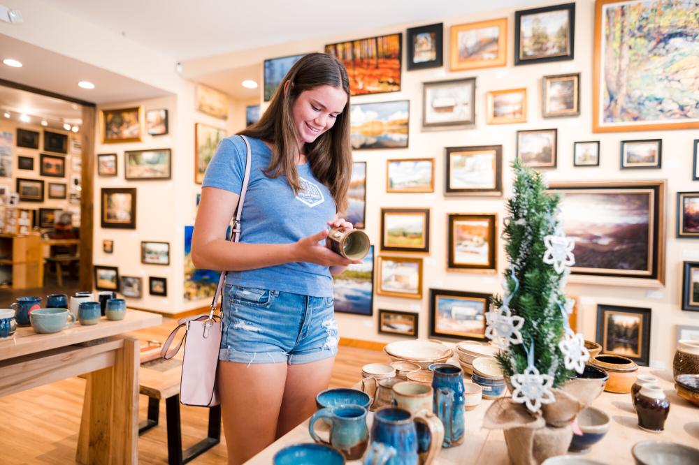 A teenager girl browses at an arts and crafts gallery.