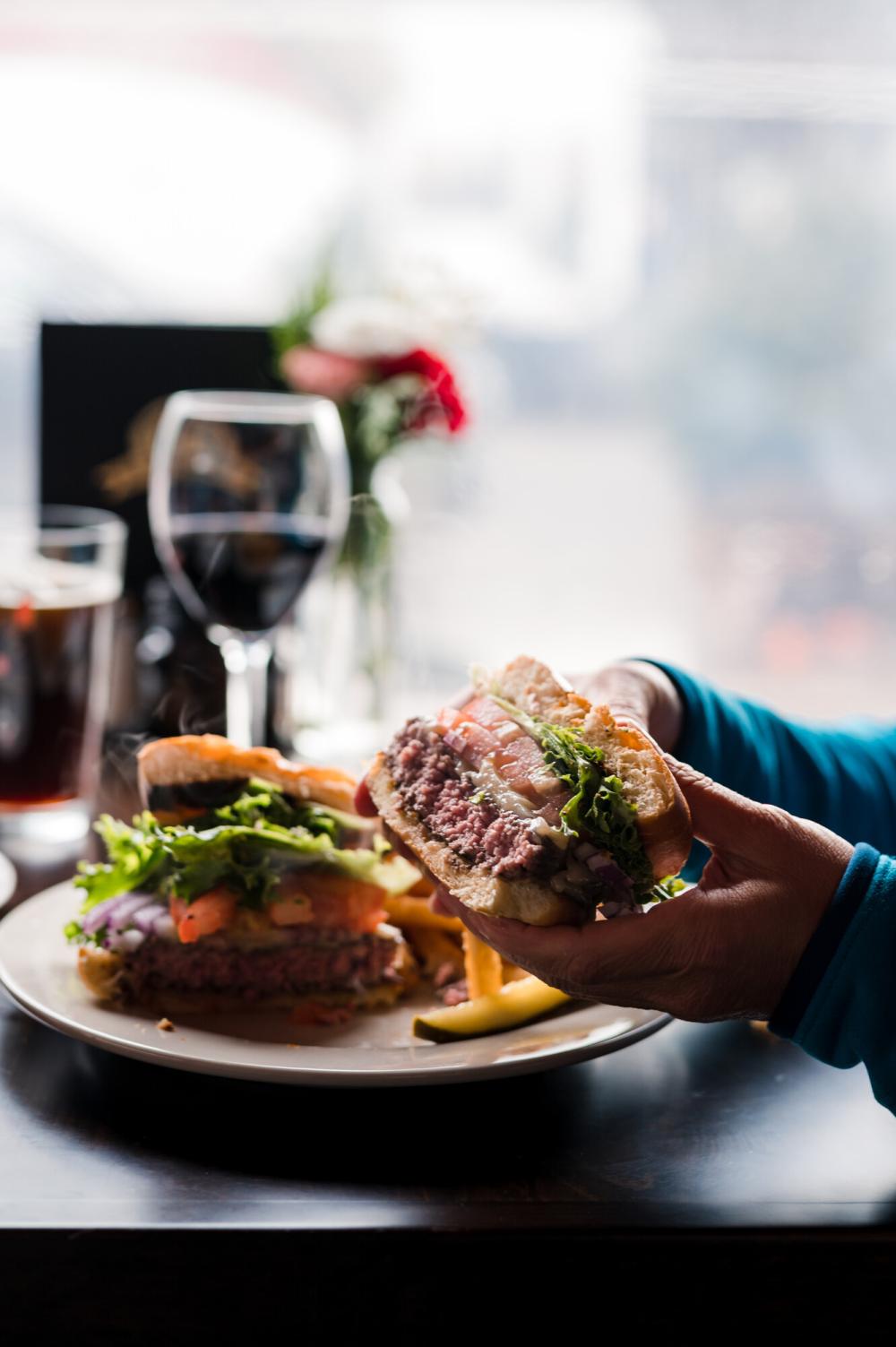 A juicy burger is held to take a bite.