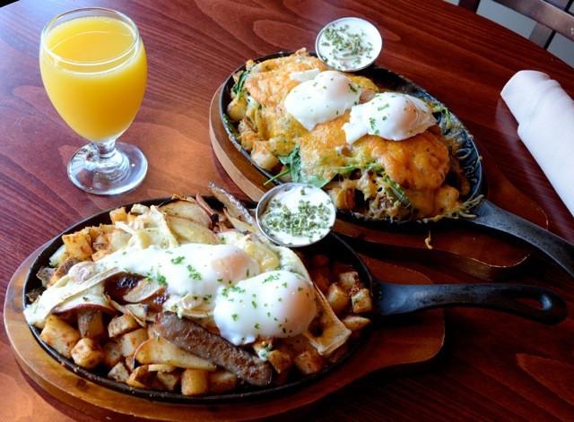 Two skillets of over-easy eggs, potatoes, and cheese.