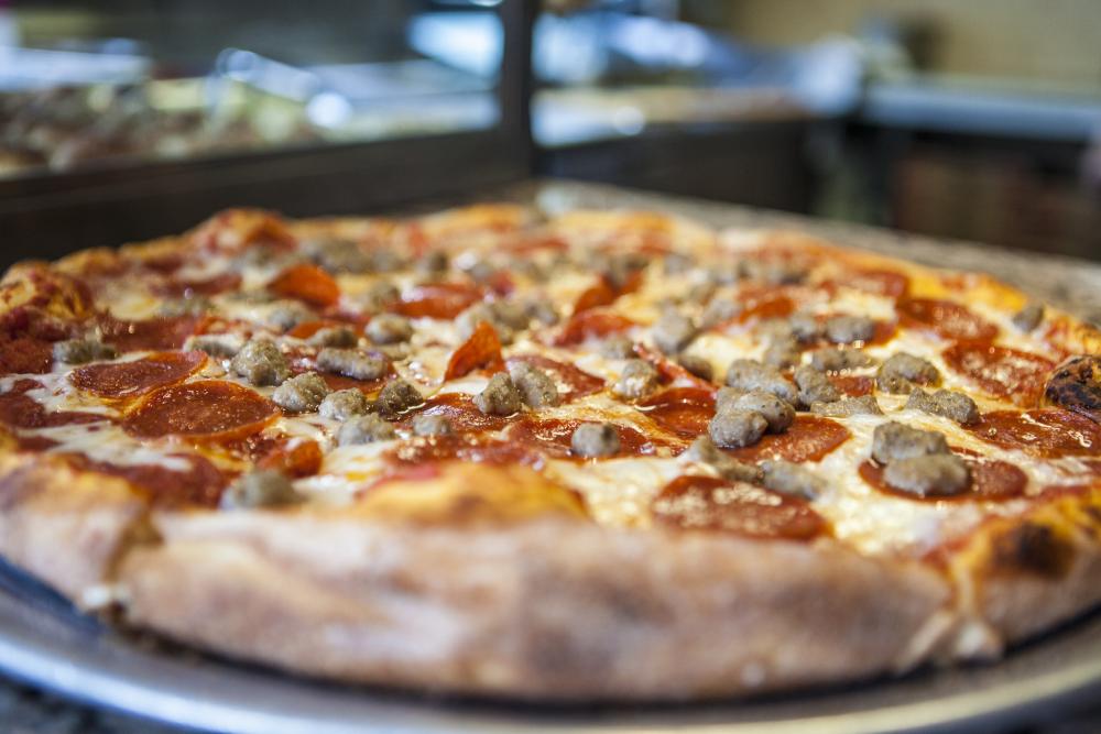 A close up of a pepperoni and sausage pizza.