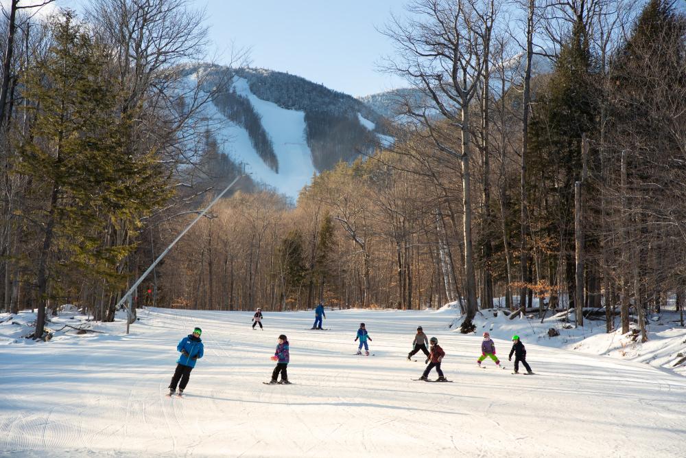 A group of kids skiing down an easy slope.