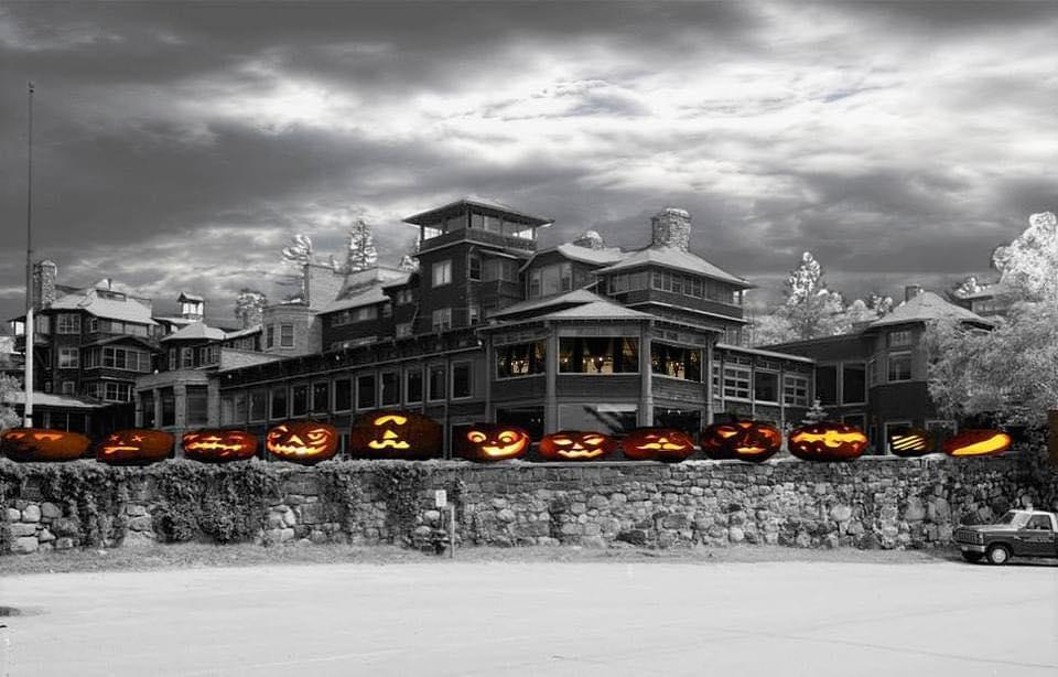 A black and white image of an old Adirondack hotel, photoshopped with spooky cartoon pumpkins