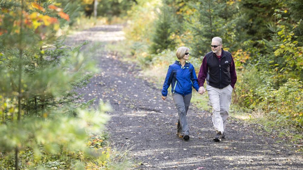 Couple walks down Saranac Lake Rail Trail