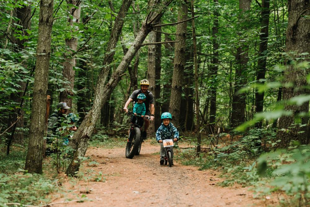 A father and his son mountain biking a flat trail