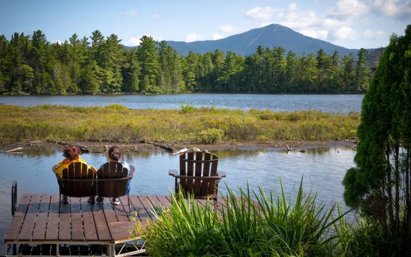 Two people sitting on a deck with views of the mountains