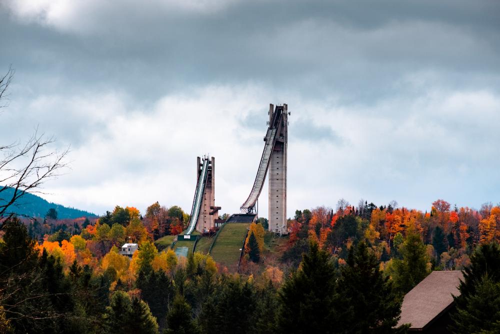 Olympic ski jumps in the distance with fall scenery.