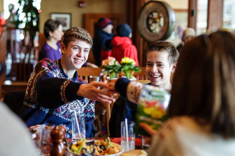 A family in sweaters cheerses their drinks.