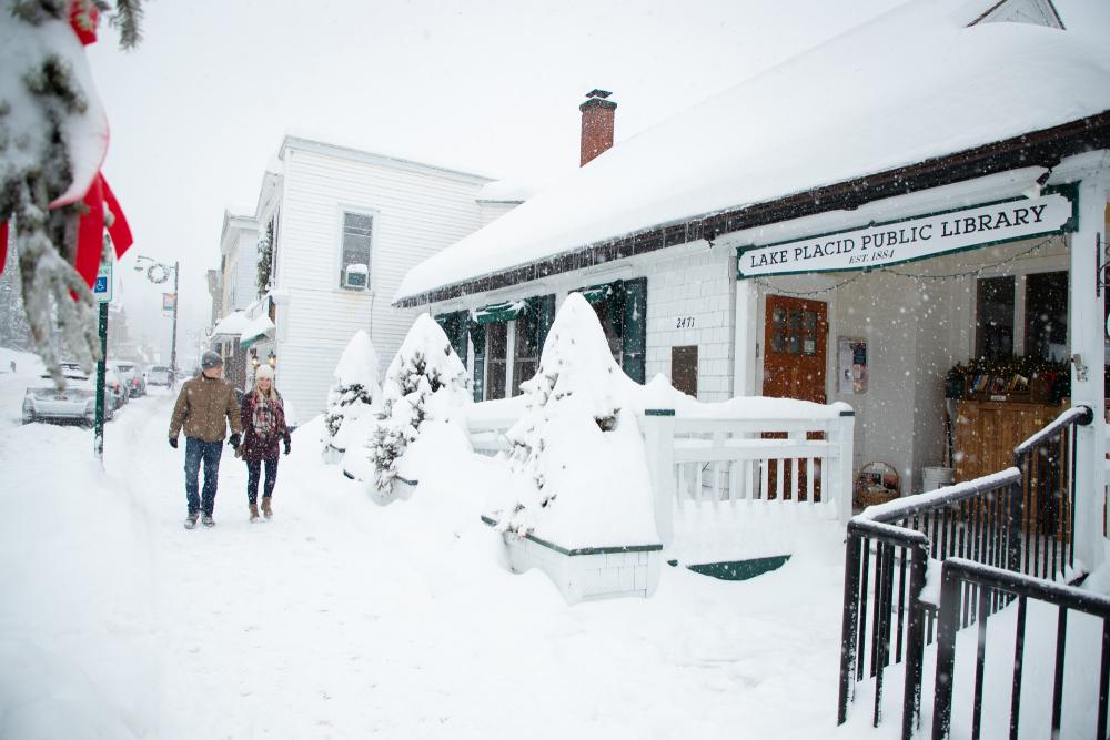 Couple walks down snowy Main Street