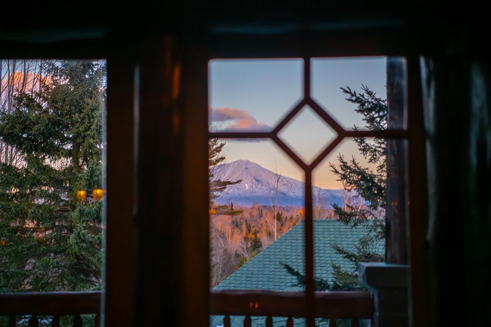 A look at a mountain from a snowy window.