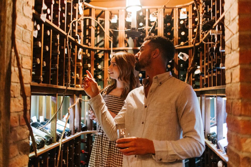 A man and woman shop for wine.