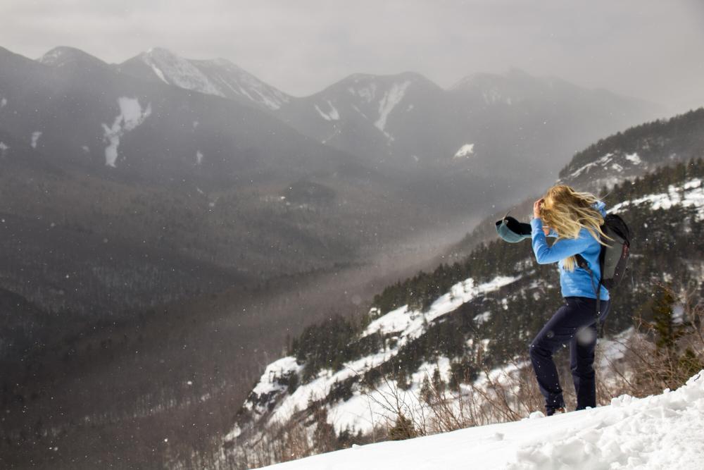 A winter hiker on a cliff of the Three Brothers