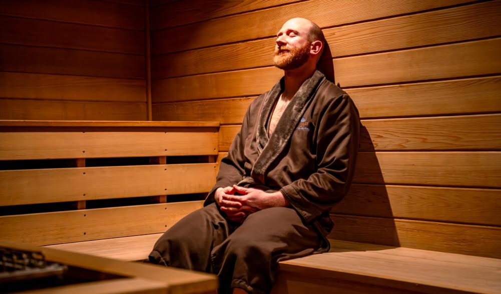 A man sits in a warm sauna
