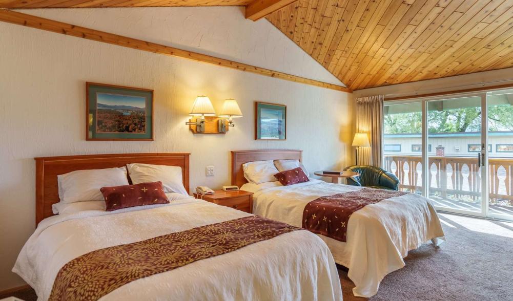 A large, yet cozy Adirondack hotel room with double beds and a high ceiling.