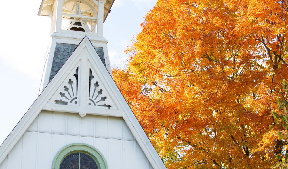 A white church steeple in fall.