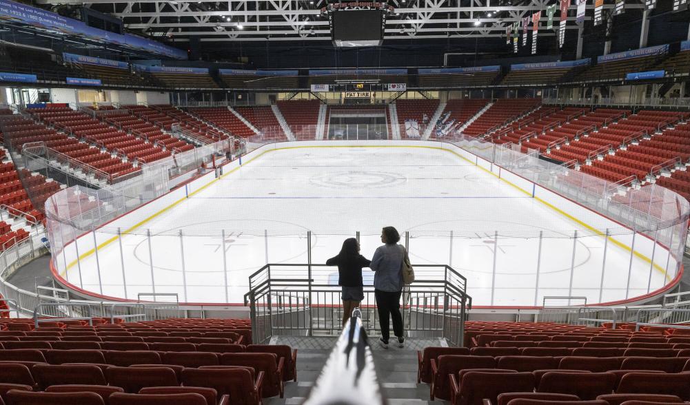 Two people look towards the ice of the 1980 Rink