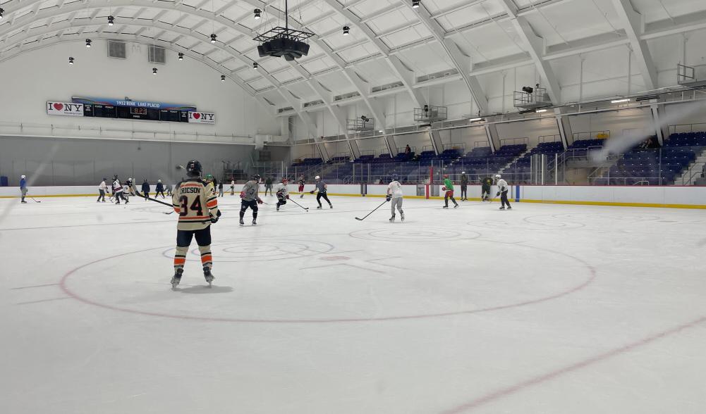 Hockey teams compete at an indoor rink.