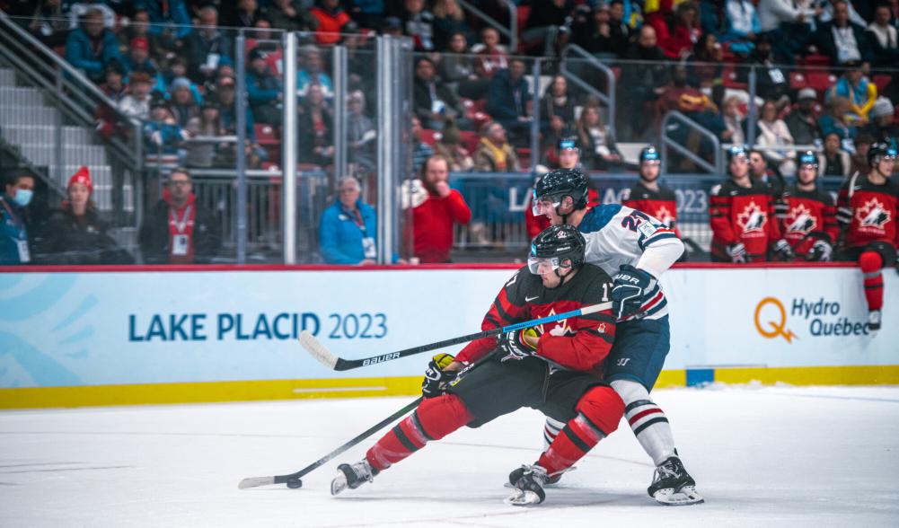 Two international hockey players fight for the puck.