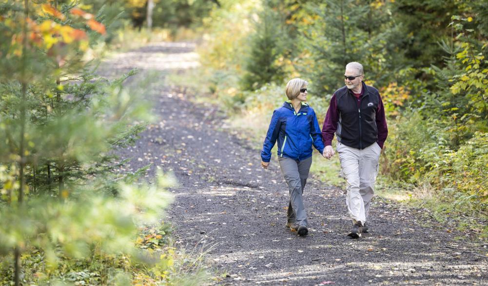 Couple walks down Saranac Lake Rail Trail