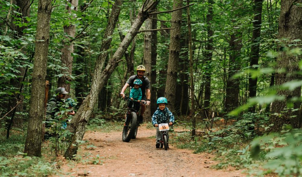 A father and his son mountain biking a flat trail