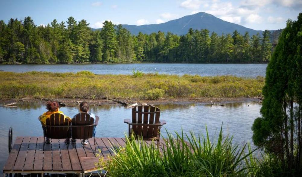 Two people sitting on a deck with views of the mountains